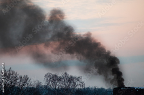black smoke from the chimney against the sky