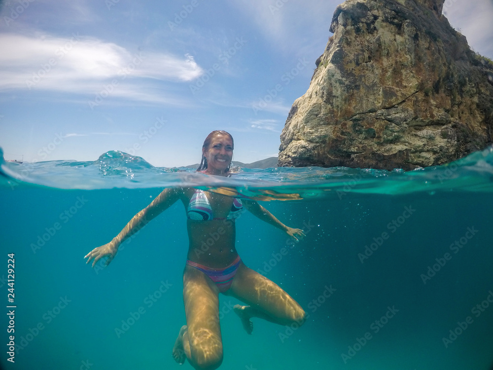 Beautiful young woman swimming in the ocean