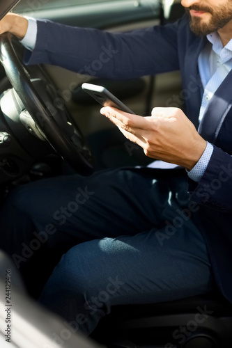 Handsome bearded man use smartphone in car