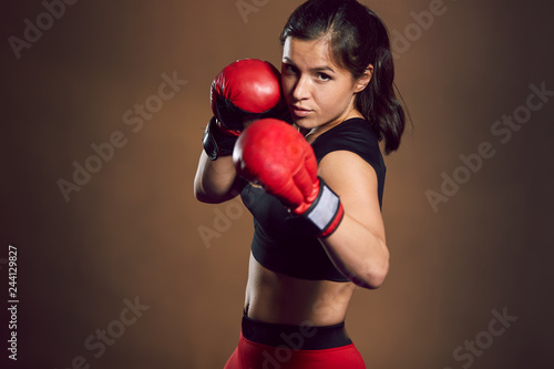 Young athletic girl fighter trains in the gym.