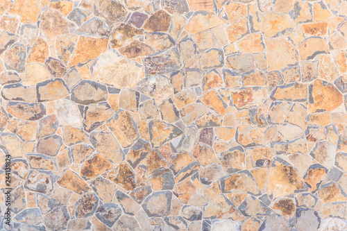 Rustic wall texture of irregular brown stone wall.