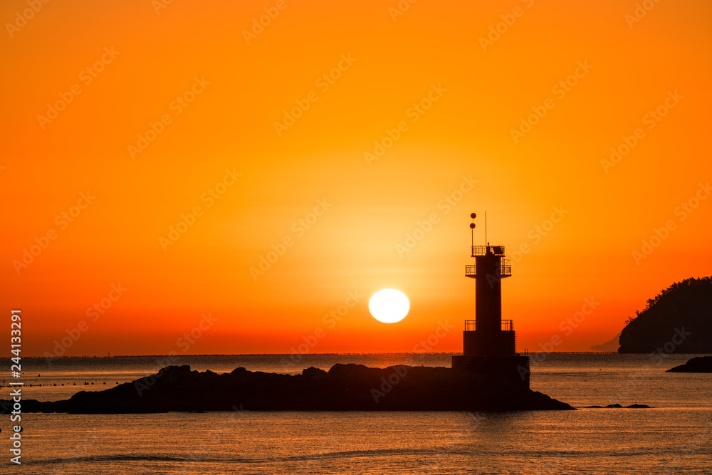 등대 너머에서 떠오르는 태양