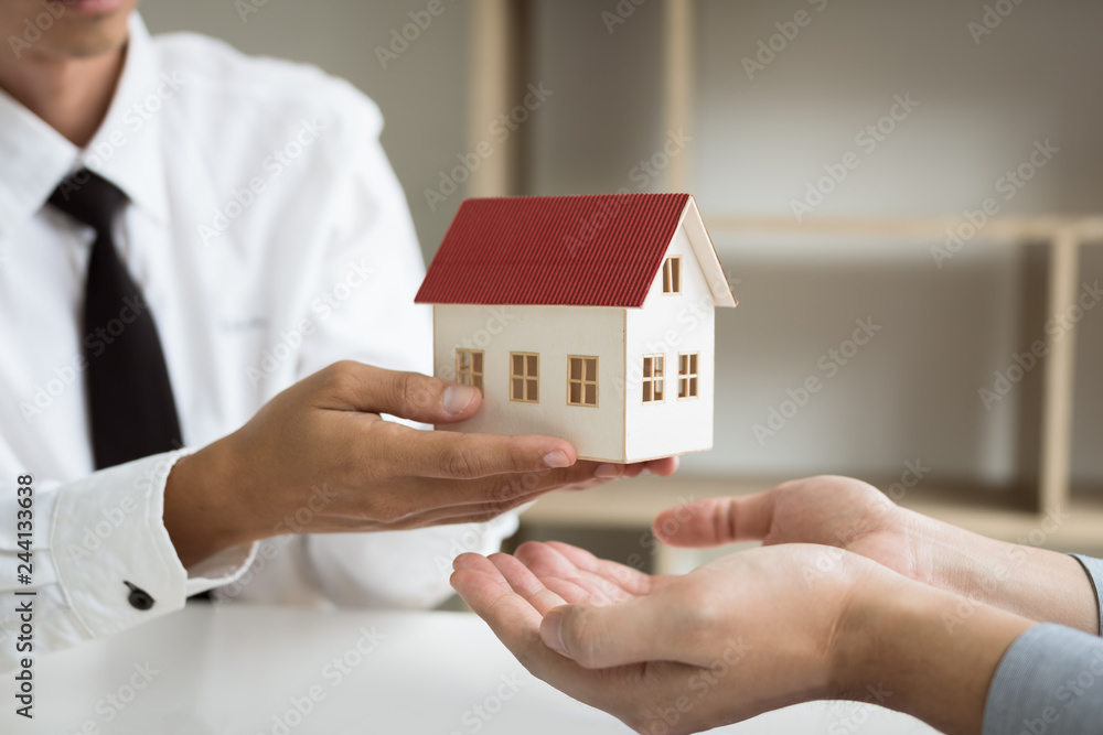 Home agents are giving house gifts to new home buyers in office room. Home agents are giving house gifts to new home buyers in office room.