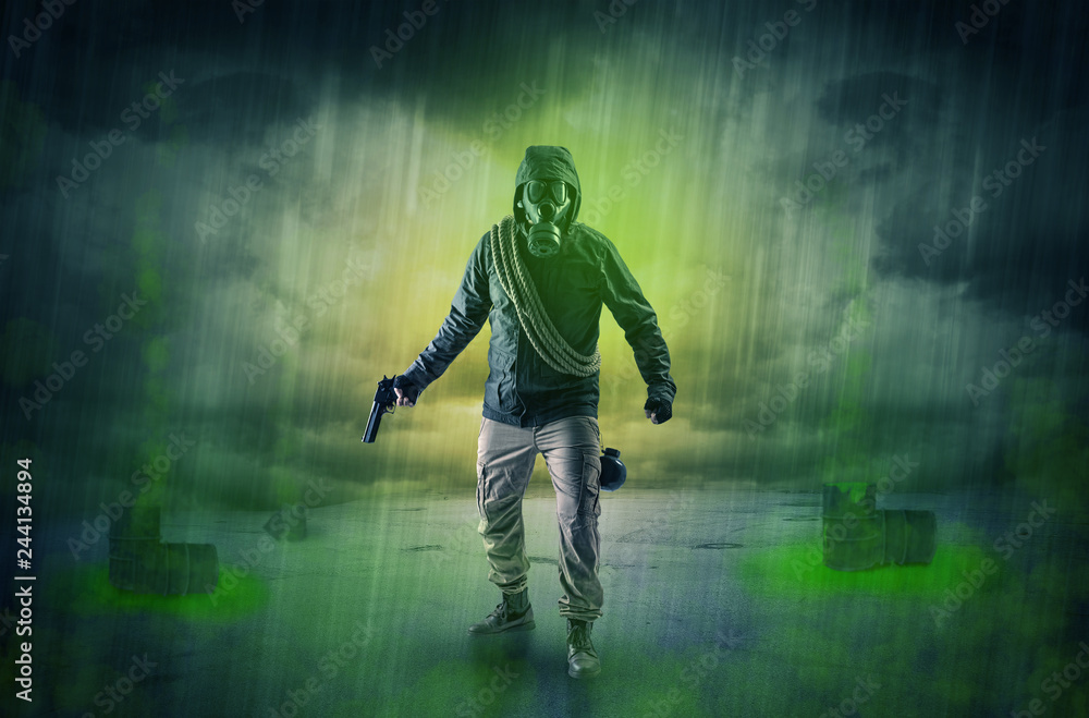 Fototapeta premium Masked unrecognizable guard in an abandoned space after explosion 