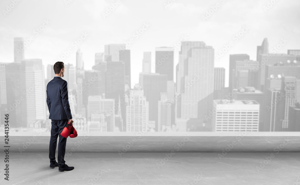 Businessman standing with his back on a roof with objects in his hand
