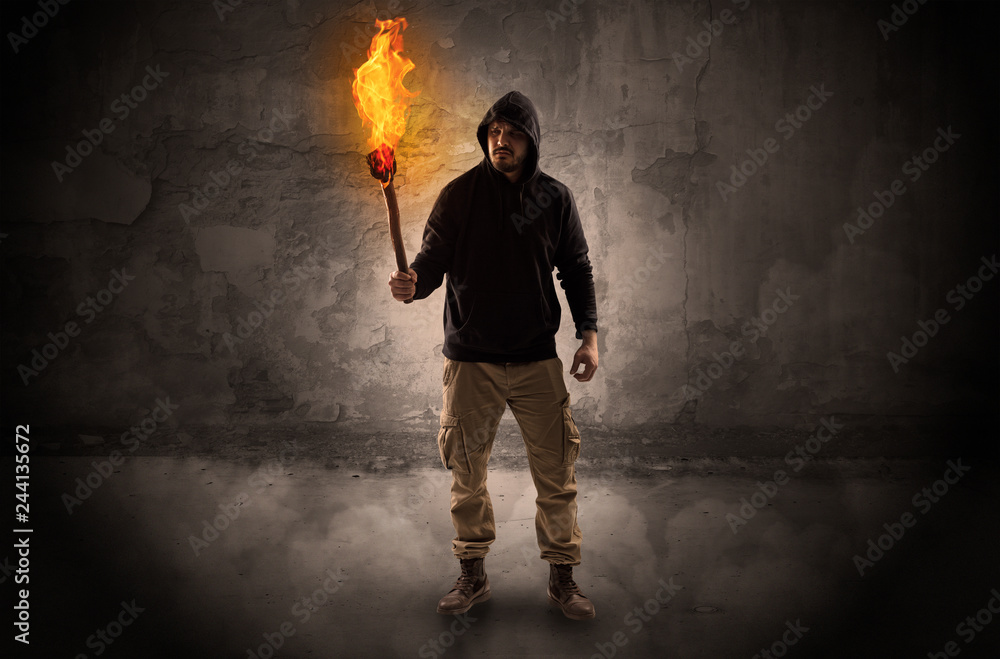 Ugly wayfarer with burning torch in his hand in front of a crumbly wall concept
Ugly wayfarer with burning torch in his hand in front of a crumbly wall concept