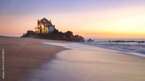 Landscape over the beach of miramar with view to chapel of senhor da Pedra at blue hour photo