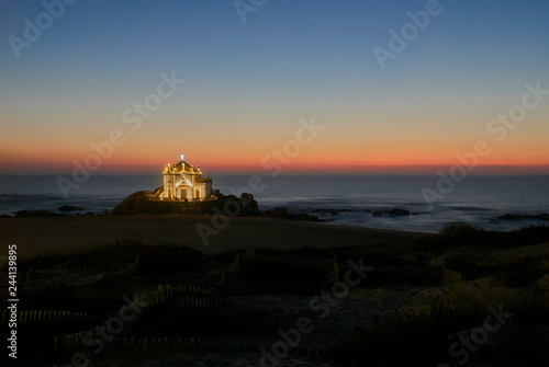 Landscape over the beach of miramar with view to chapel of senhor da Pedra at blue hour