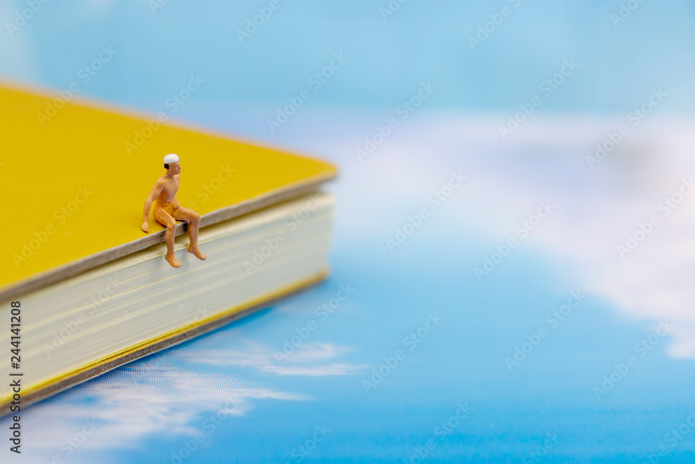 Miniature people: Tourists Sunbathing on the beach. Concept of traveling, business concept.