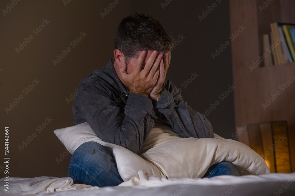young attractive sad and depressed man on bed suffering anxiety crisis and depression problem feeling overwhelmed and stressed late at night on dramatic light young attractive sad and depressed man on bed suffering anxiety crisis and depression problem feeling overwhelmed and stressed late at night on dramatic light