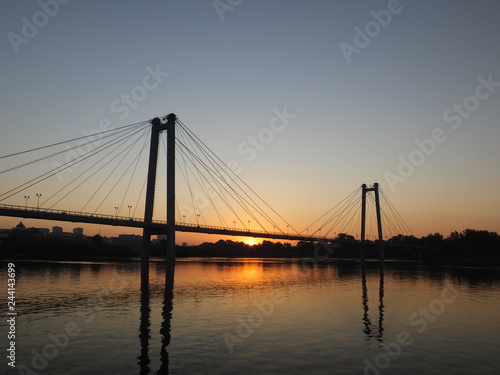 Suspension bridge over the river, illuminated by the setting sun in Krasnoyarsk city