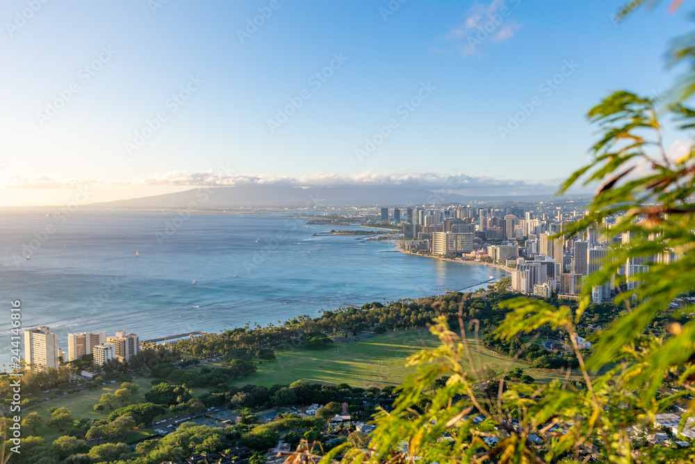 Stunning view of Honolulu and Waikiki Beach seen from the summit of Diamond Head Crater, Oahu, Hawaii. Beautiful evening just before sunset. Diamond Head is a popular hiking day trip for tourists.