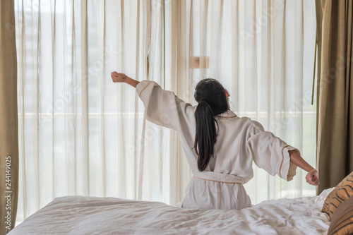 Good morning wake-up with Asian woman relaxing in hotel room