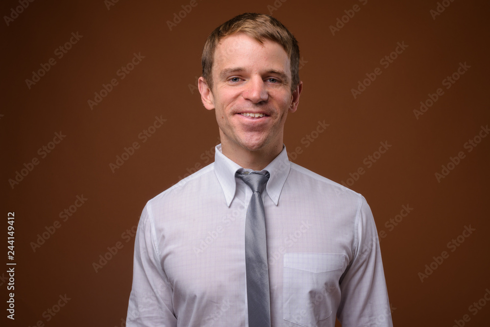 Businessman wearing white shirt against brown background Businessman wearing white shirt against brown background