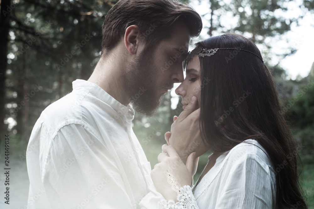 Young beautiful Slavic couple in love walks through the woods, sweet girl in a simple boho-style wedding dress. They are happy and calm. Golden hour, summer day, warm. They kiss, hug and hold hands. Young beautiful Slavic couple in love walks through the woods, sweet girl in a simple boho-style wedding dress. They are happy and calm. Golden hour, summer day, warm. They kiss, hug and hold hands.