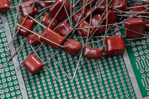 Electronic components, Lots of red film capacitors on PCB background