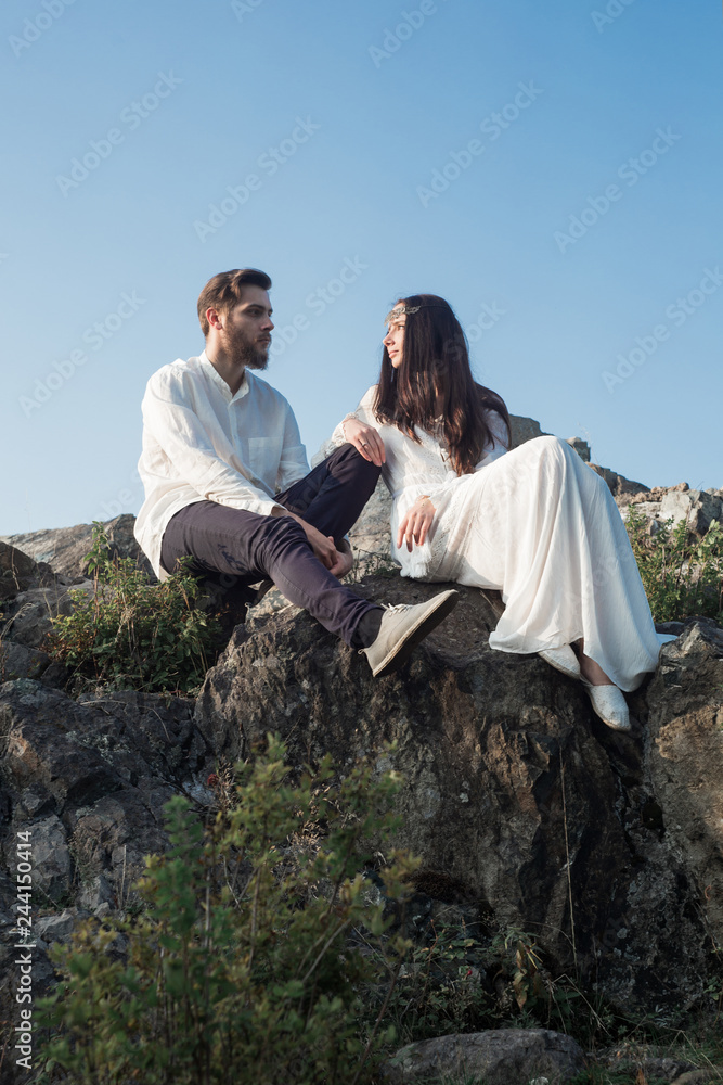 Beautiful couple in love walks in the mountains, against the backdrop of rocks, in the rays of the setting sun. man and woman love each other, they are gentle and happy, a love story and a wedding day