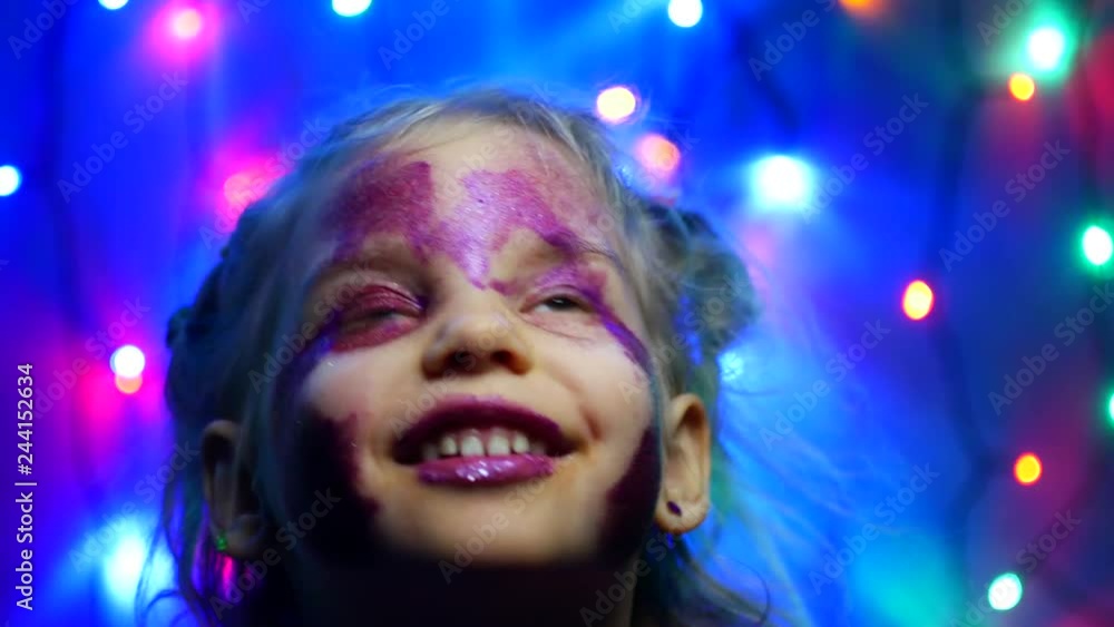 Five-year girl on the background of festive garlands. Makeup, glitter, portrait Five-year girl on the background of festive garlands. Makeup, glitter, portrait