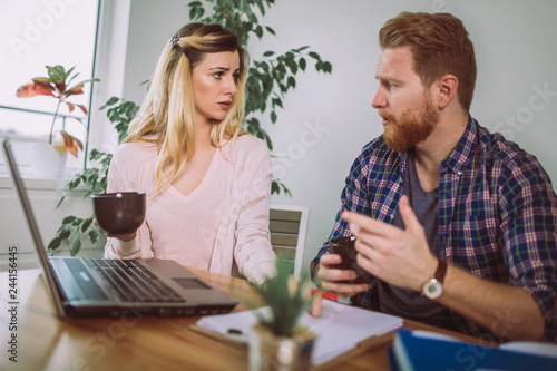 Woman and man doing paperwork together, they report online tax on the laptop.