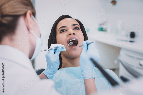 Close up of conscious dentist that examining her patient