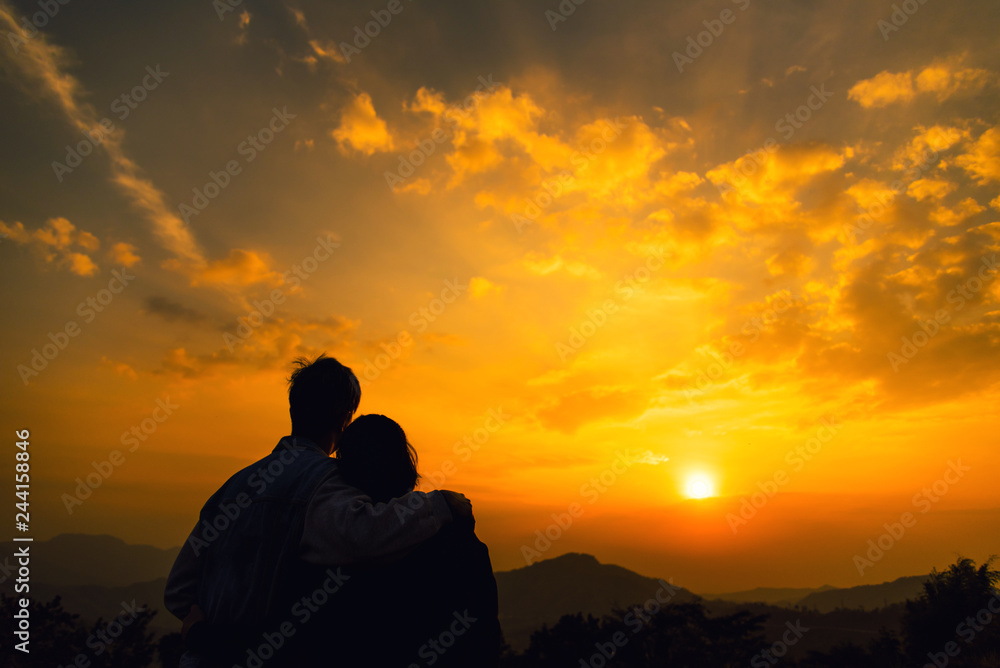 Young couple enjoying the sunset. Looking sunset at mountain