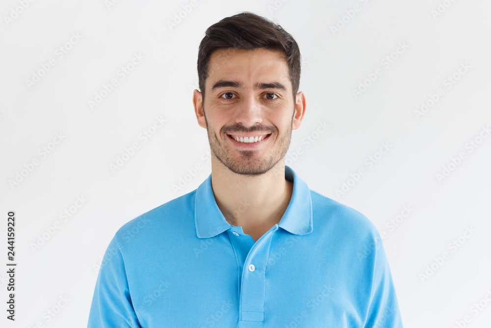 Close up portrait of young smiling handsome man in blue polo shirt isolated on gray background Close up portrait of young smiling handsome man in blue polo shirt isolated on gray background