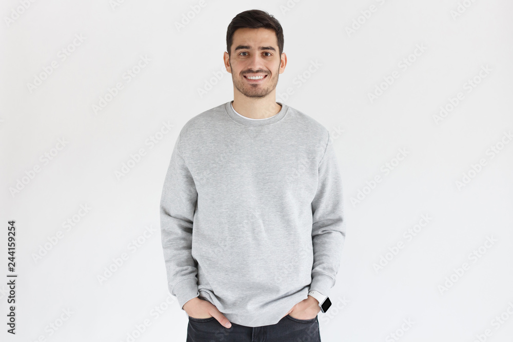 Young man in oversized sweatshirt, isolated on gray background Young man in oversized sweatshirt, isolated on gray background