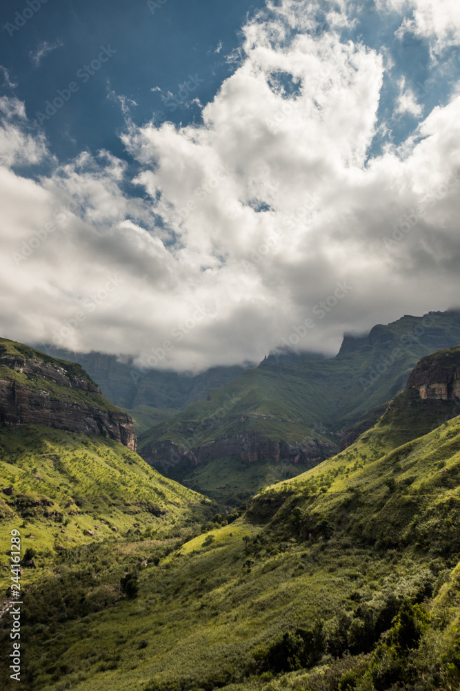 Ciffs and mountain sides under dramatic skies on the Thukela hike to the bottom of the Amphitheatre's Tugela Falls in the Royal Natal National Park, Drakensberg, South Africa