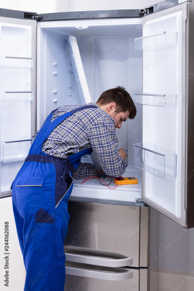 Serviceman Checking Fridge Serviceman Checking Fridge