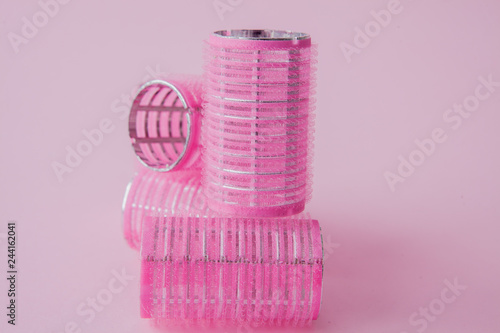 Curlers hair plastic on a pink background with copy space