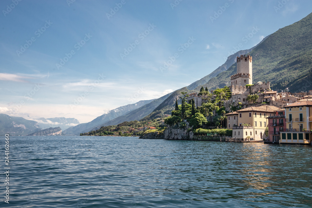View from water on coastal town Malcesine with ancient Scaliger castle on lake Garda