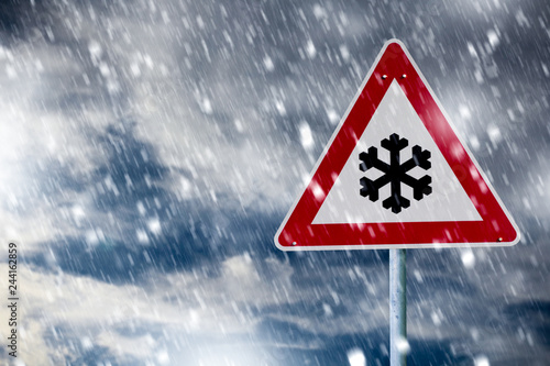 Straßenglätte. Verkehrsschild im Schneegestöber