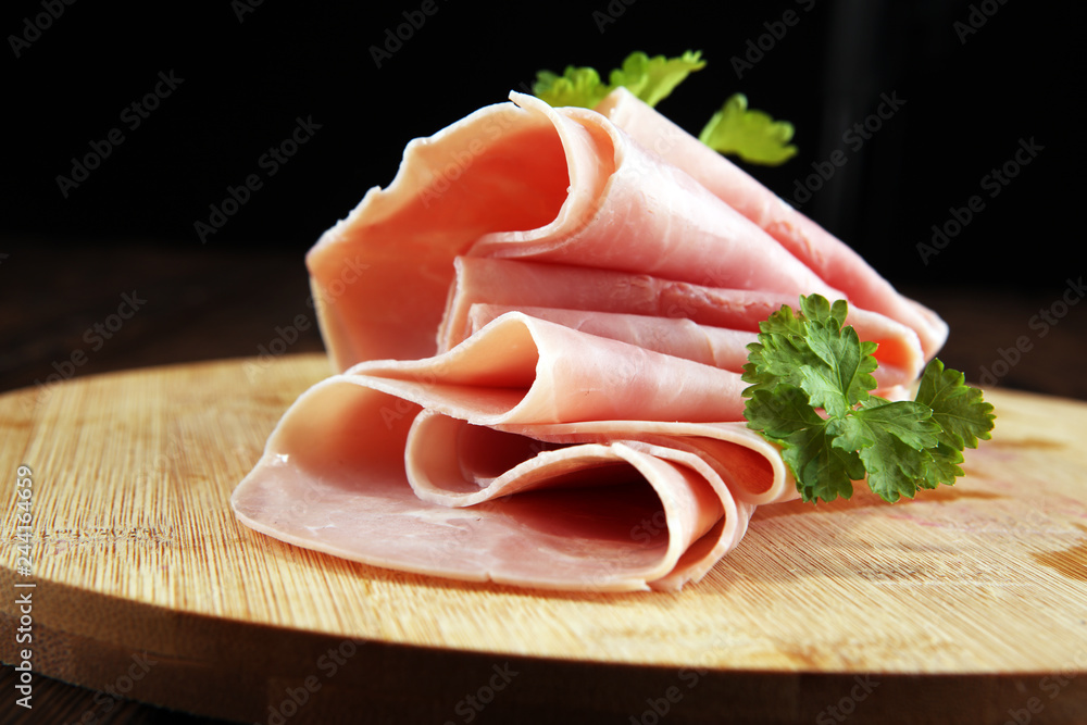 Sliced ham with parsley on table. Fresh prosciutto. Pork ham sliced. Sliced ham with parsley on table. Fresh prosciutto. Pork ham sliced.