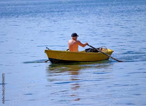 Man rowing a row boat © Elba Cabrera