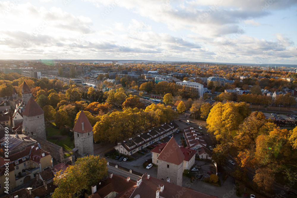 TALLINN, ESTONIA - OCTOBER 15, 2017: Aerial view on the foliage around old town towers and wall, Tallinn, Estonia. Bright autumn day.