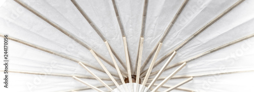 a fragment of umbrella construction made of wood and white paper