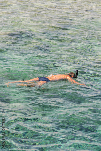man with snorkel mask tuba and snorkel in sea. Snorkeling, swimming, vacation. Tourists are engaged in snorkeling in the open sea. Holidays in the seaside resort. vertical photo.