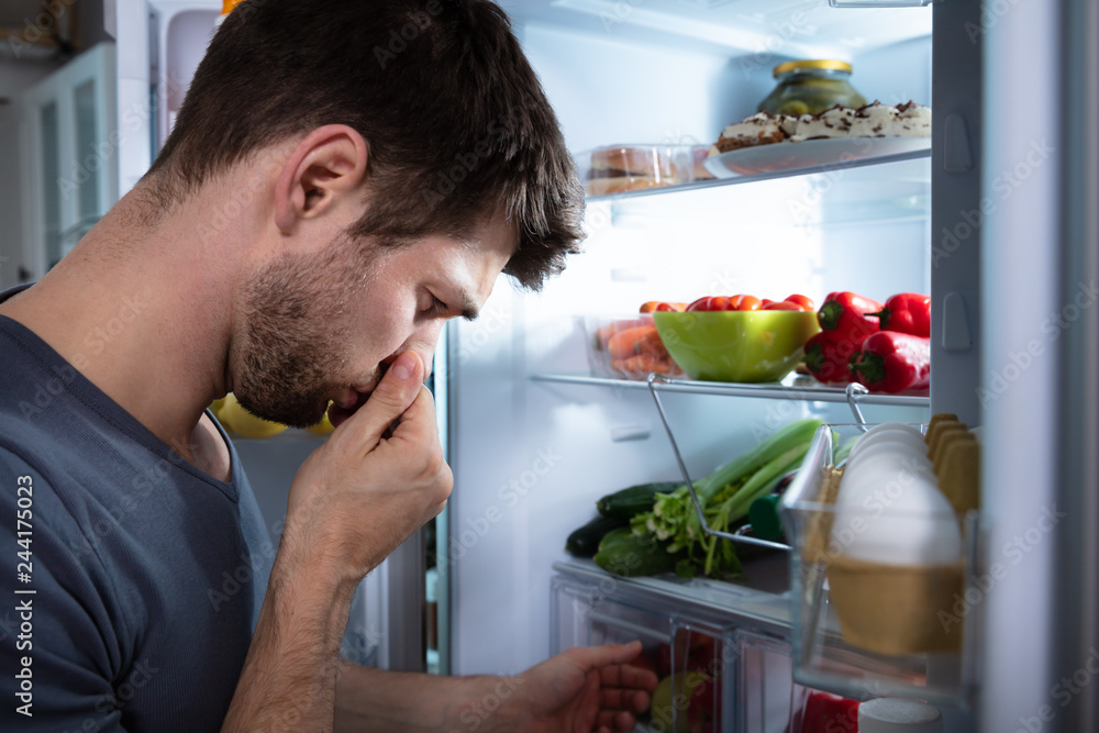 Man Recognizing Bad Smell From The Refrigerator Man Recognizing Bad Smell From The Refrigerator
