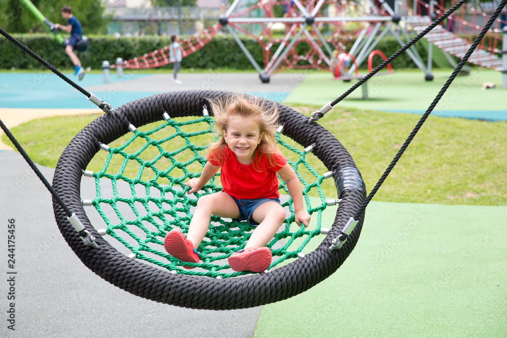 Cheerful girl swinging in the swing-nest Cheerful girl swinging in the swing-nest