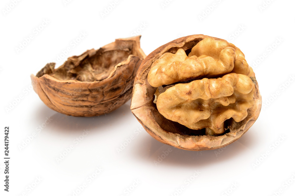 Broken ripe walnut with full kernel and shell, close up macro, isolated on a white background. Broken ripe walnut with full kernel and shell, close up macro, isolated on a white background.