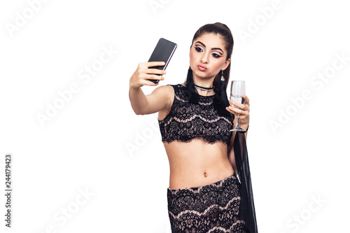 young gorgeous girl holds a glass of champagne and taking selfie. photo