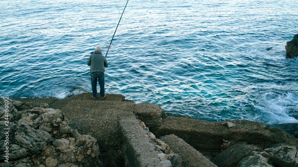 An old man fishing in Palermo, Sicily