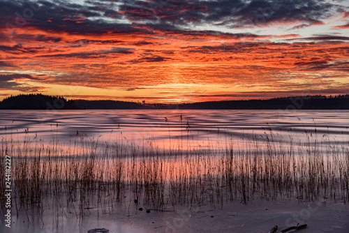 Orange sunset over frozen lake in Sweden photo