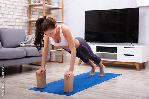 Woman Using Wooden Blocks While Doing Exercise