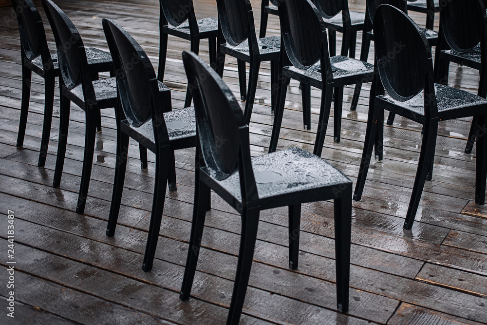 Black chairs in the rain on the street Black chairs in the rain on the street