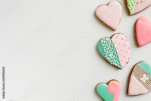 Painted pink and colored, ginger and honey cakes and cookies. In the shape of a heart. On a light wooden background. Frame. Place for text. The concept of love, mother's day, cooking, St. Valentine. photo