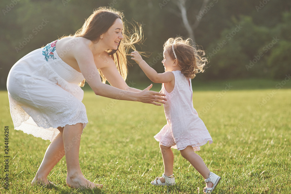 Naklejka premium Happy family, active mother with little child, adorable toddler girl