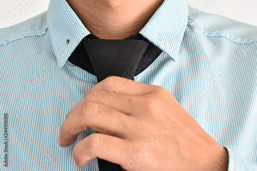 Businessman adjust necktie his shirt