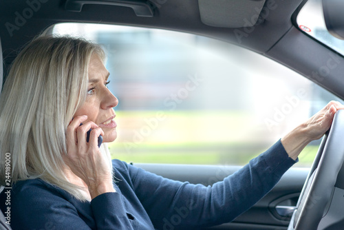 Mature woman chatting on her mobile in the car