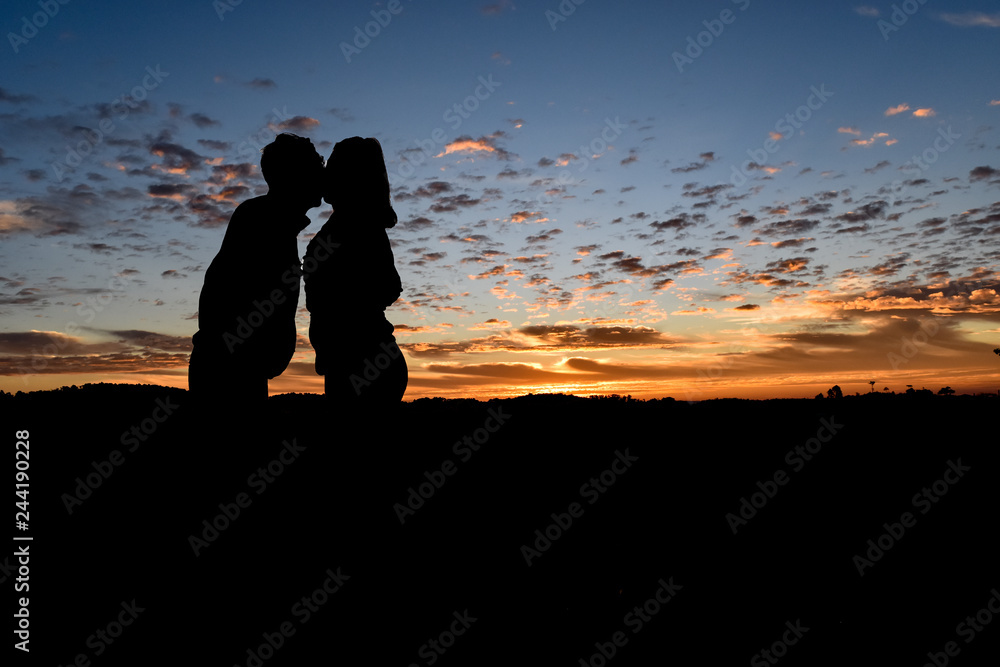 Silhouette Romantic couple in love ,man and women in nature ,sky with cloud in sunrise time. Valentine concept.